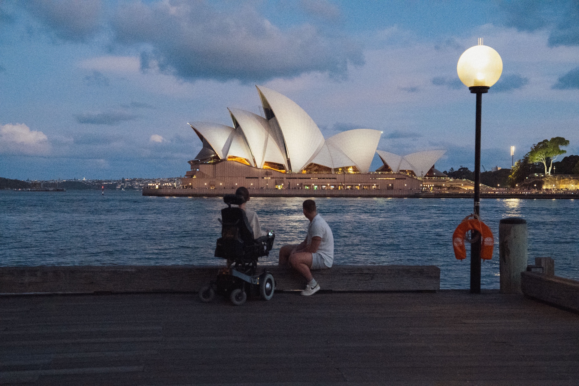 Sydney Opera House i skumringen, sett fra havnepromenaden