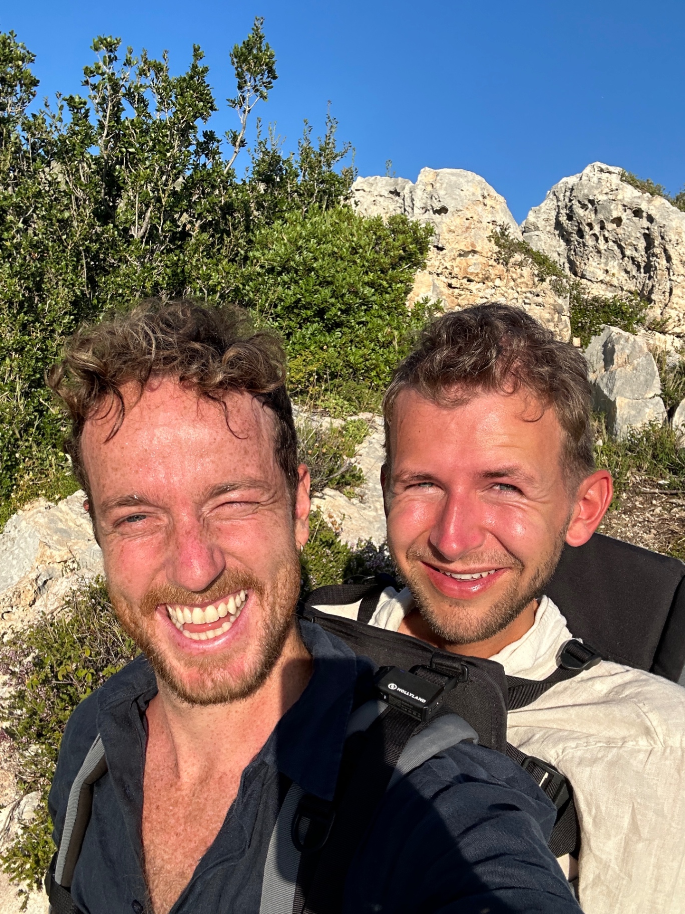Daniel og assistent smiler i fjellterreng